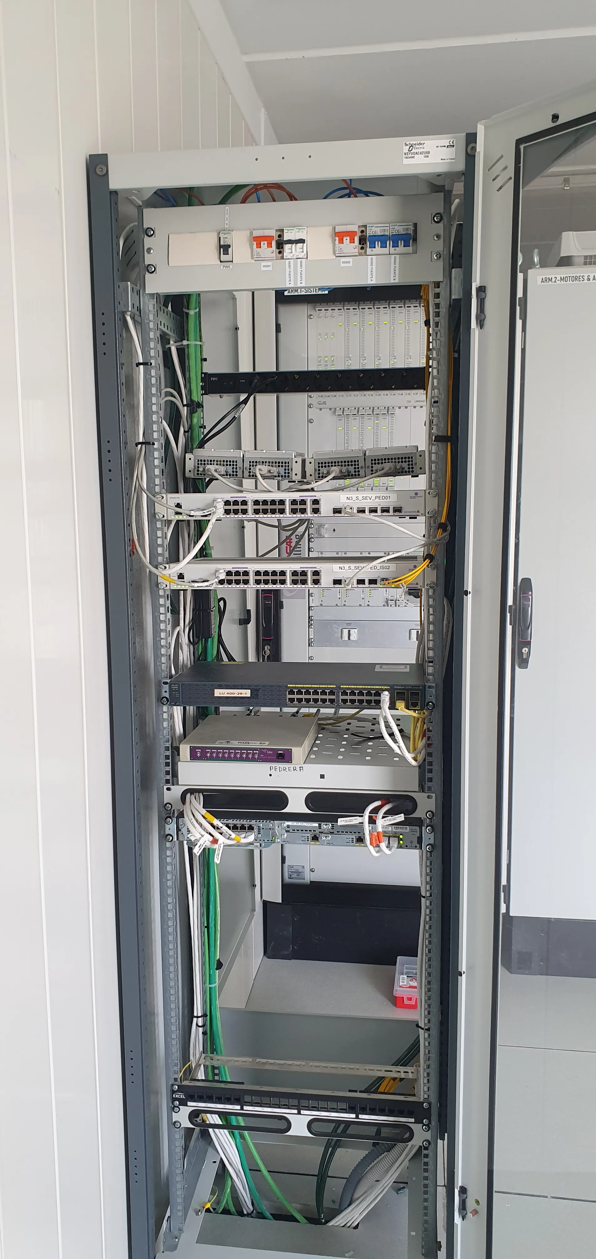 Armario técnico de comunicaciones con alimentación DC, electrónica de control y cableado organizado en entorno de infraestructura crítica