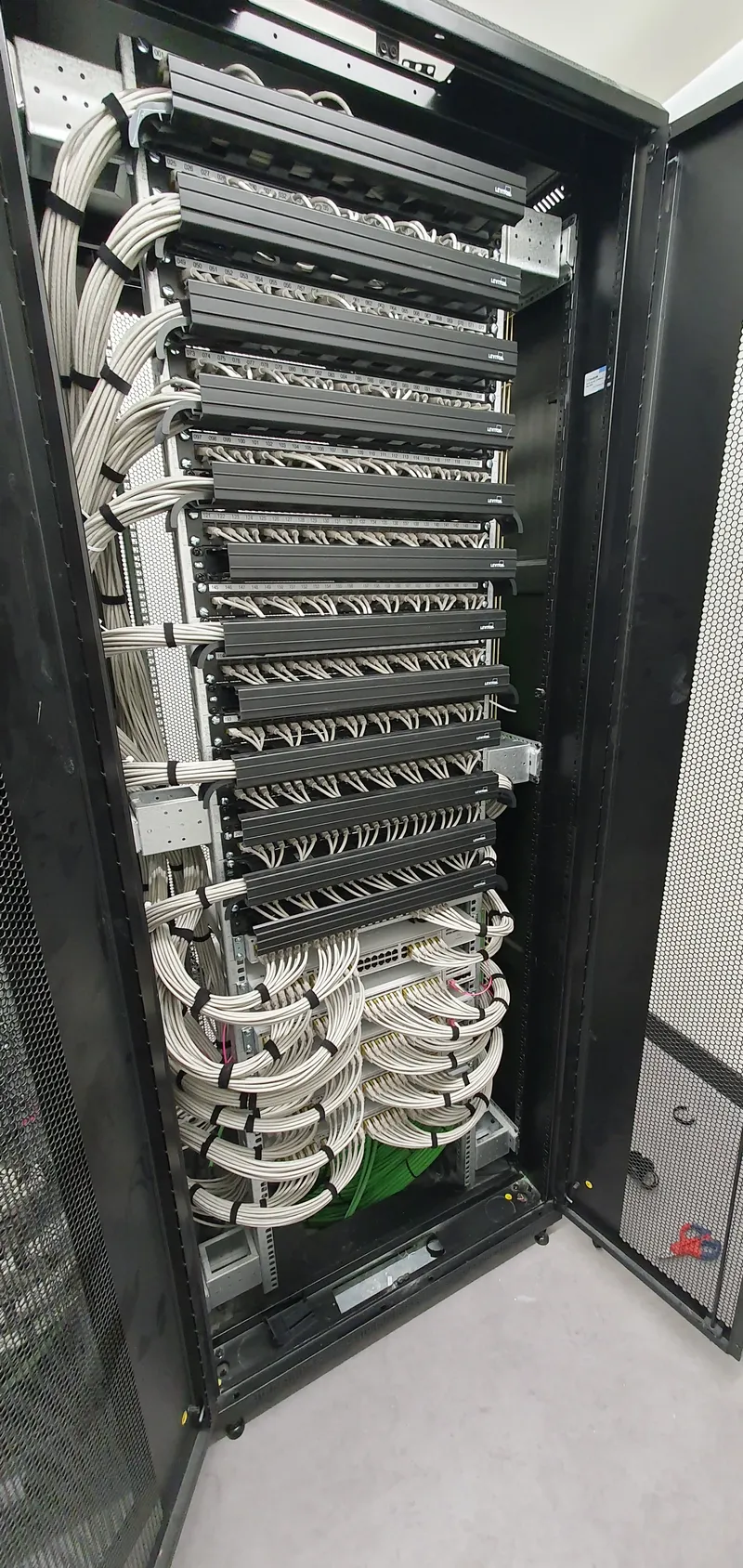 Rack de comunicaciones profesional con cableado estructurado ordenado y etiquetado