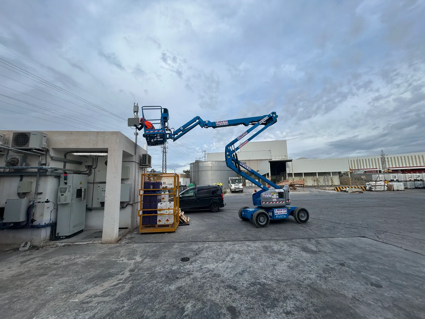 Plataforma elevadora azul extendida al máximo para alcanzar instalación en cubierta