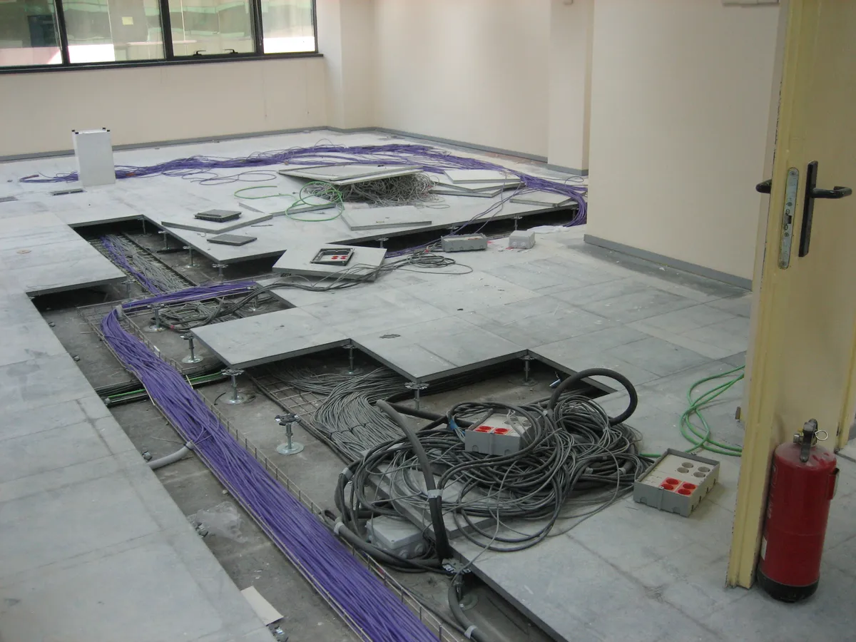 Initial state of raised floor with disorganized cabling
