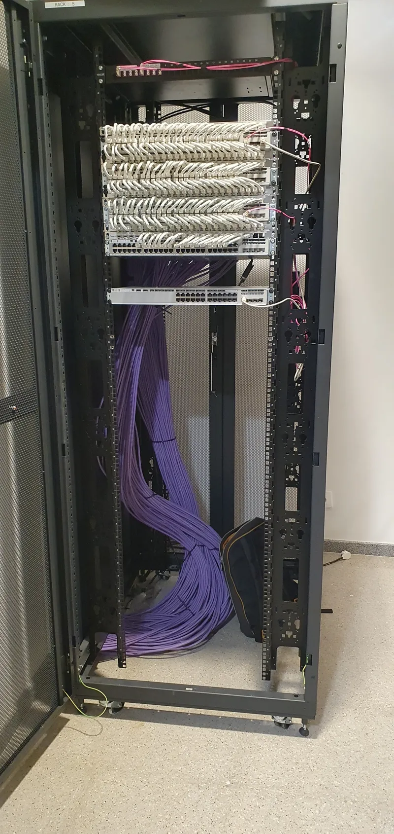 Vista trasera de rack con mazos de cable estructurado guiados verticalmente